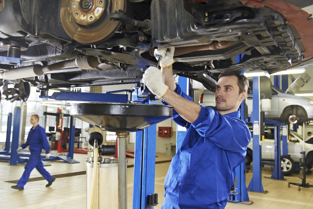 An auto mechanic repairing the suspension on a car